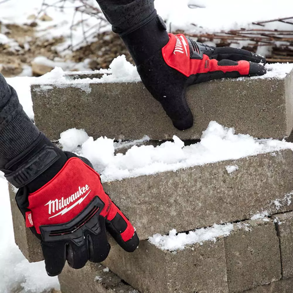 Milwaukee demolition gloves worn by someone working in the snow 