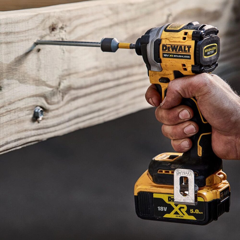 DeWalt 18V XR brushless impact driver driving a long hex-shank screw into a timber beam, demonstrating the tool's high-torque fastening performance on a woodworking project.