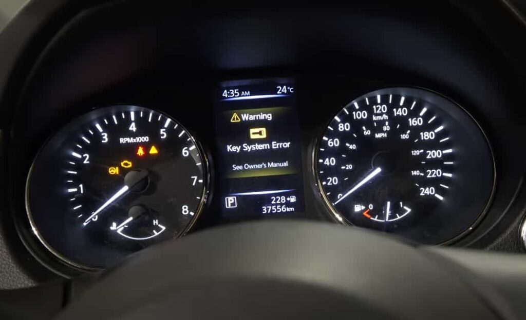 How to Jump Start A Car 3 Vehicle dashboard instrument cluster displaying multiple warning lights and a central message reading โKey System Error โ See Ownerโs Manual.โ The display shows the time as 4:35 AM, an outside temperature of 24ยฐC, and an odometer reading of 37,556km, with the speedometer and tachometer visible on either side.